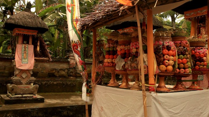 A table covered with tall offerings of fruit and other food.